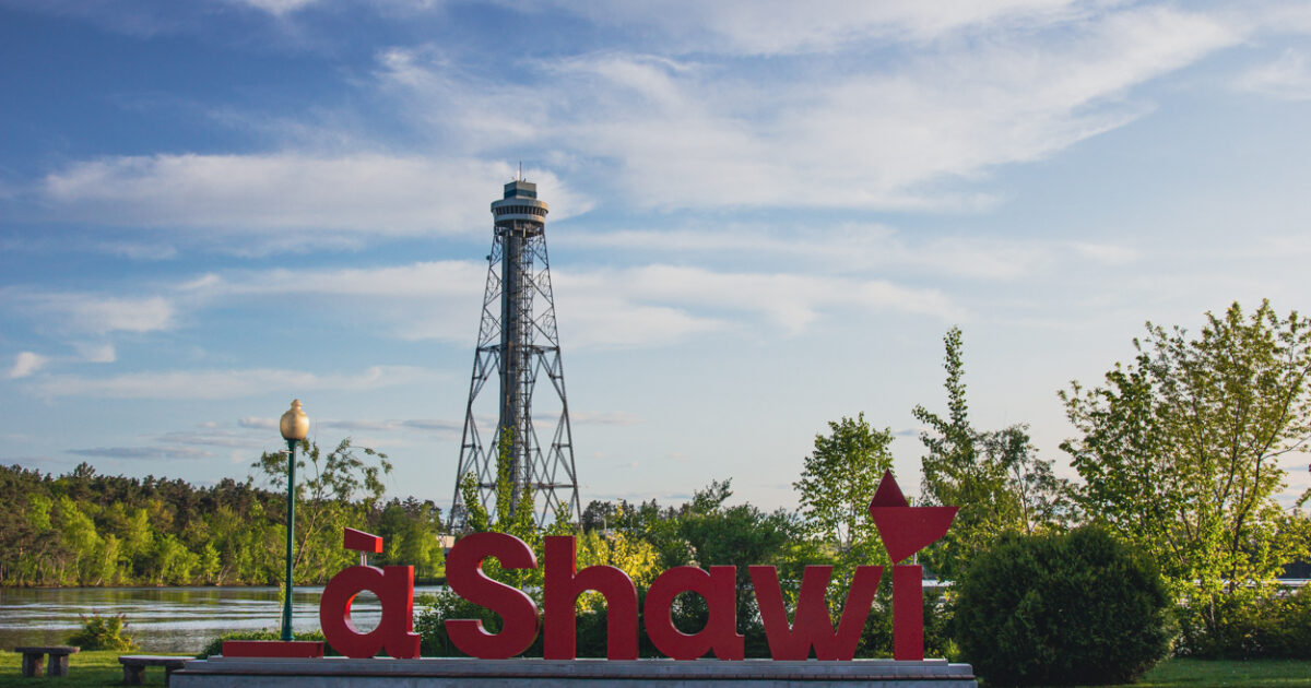 Lettres rouges « à Shawi » au bord de la rivière, avec une tour en arrière-plan